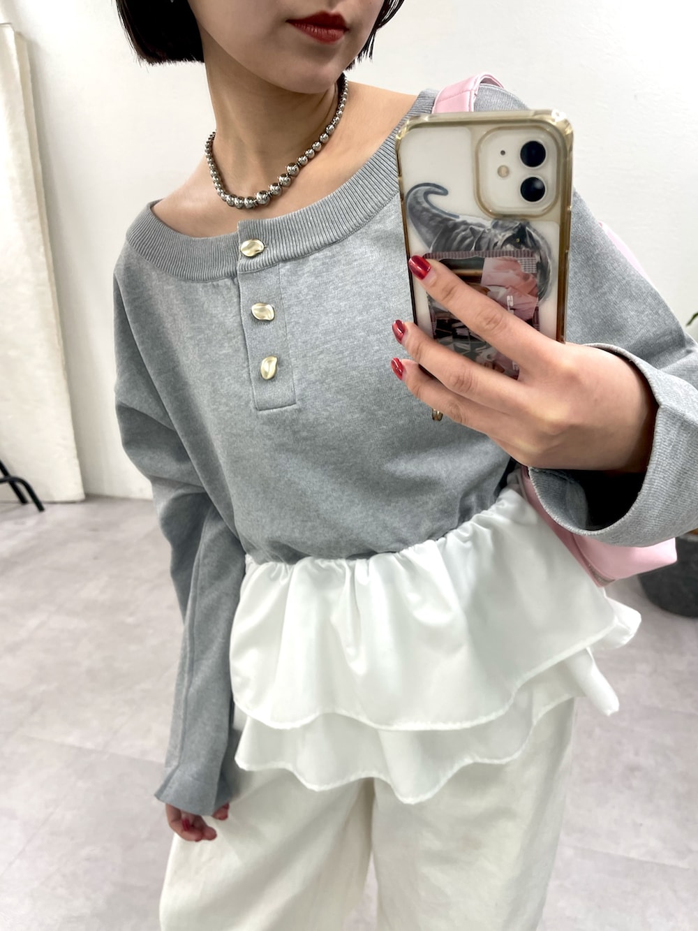 グレー系のニット/セーター、ホワイト系のデニムパンツを着用したレディースの冬コーディネートの3枚目の写真