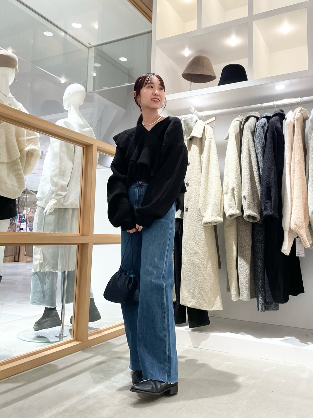 ブルー系のデニムパンツ、ブラック系のニット/セーターを着用したレディースの秋コーディネートの3枚目の写真