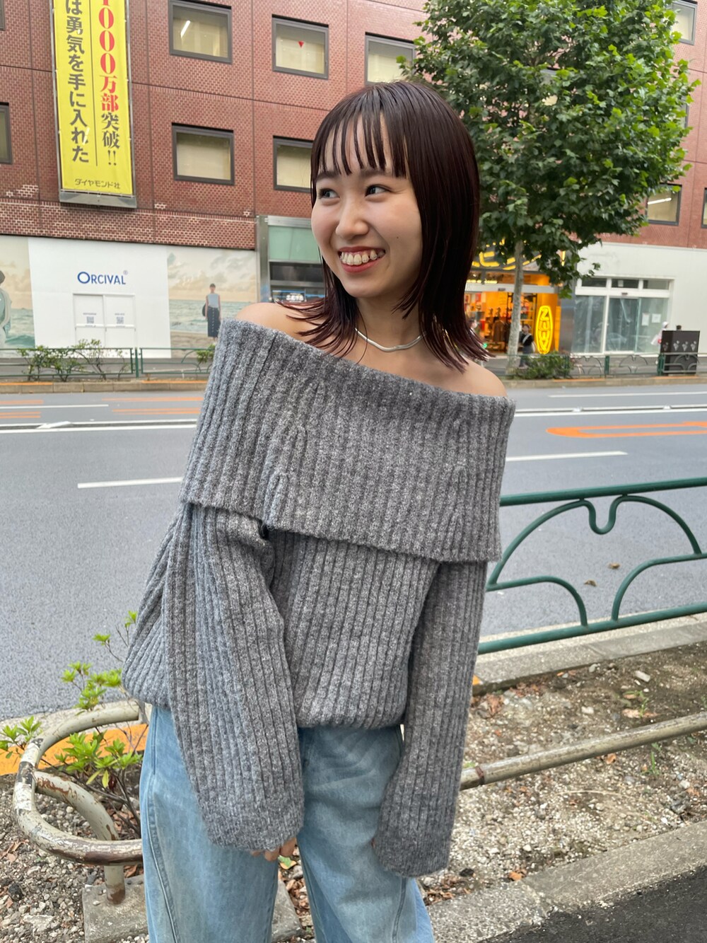 グレー系のニット/セーター、ブルー系のデニムパンツを着用したレディースの秋コーディネートの4枚目の写真