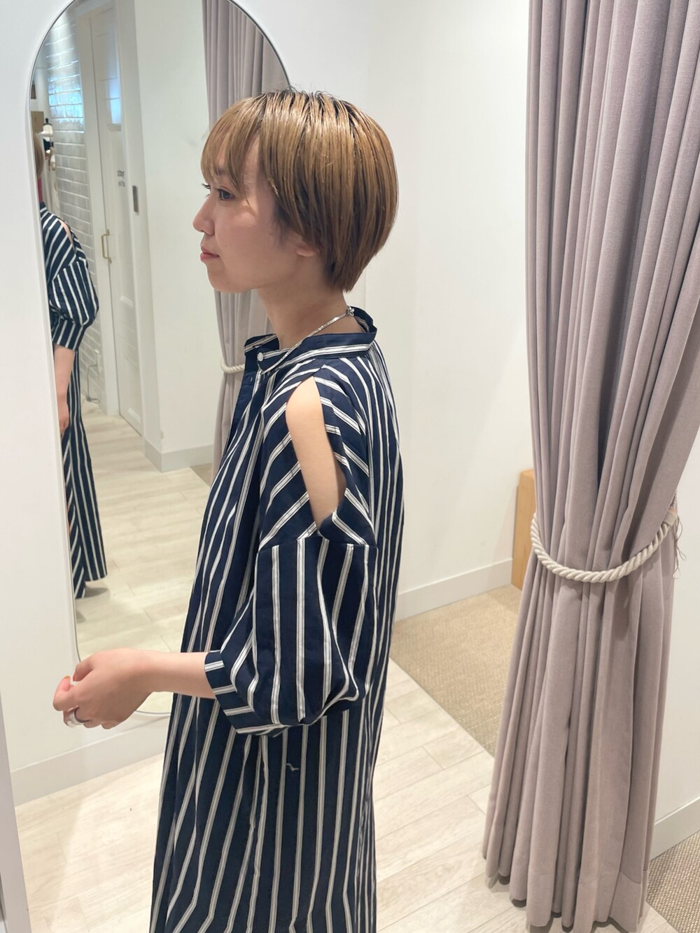 ブルー系のワンピース、ブルー系のハンドバッグ、ブラック系のサンダルを着用したレディースの夏コーディネートの2枚目の写真