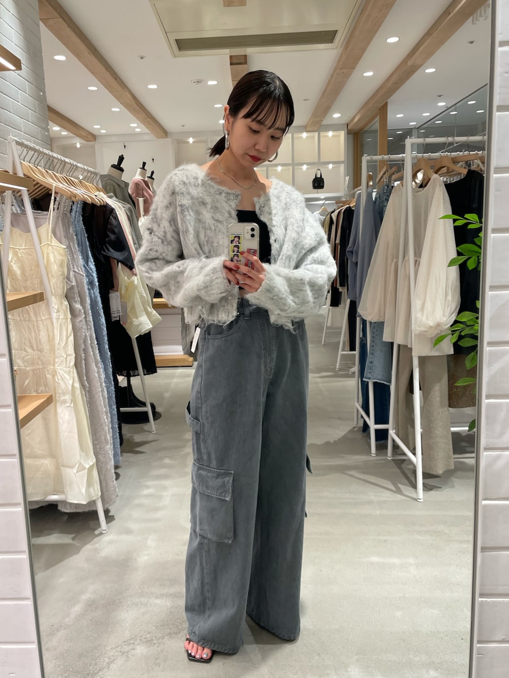 グレー系のカーディガン/ボレロ、ブラック系のキャミソール、グレー系のデニムパンツを着用したレディースの秋コーディネートの3枚目の写真