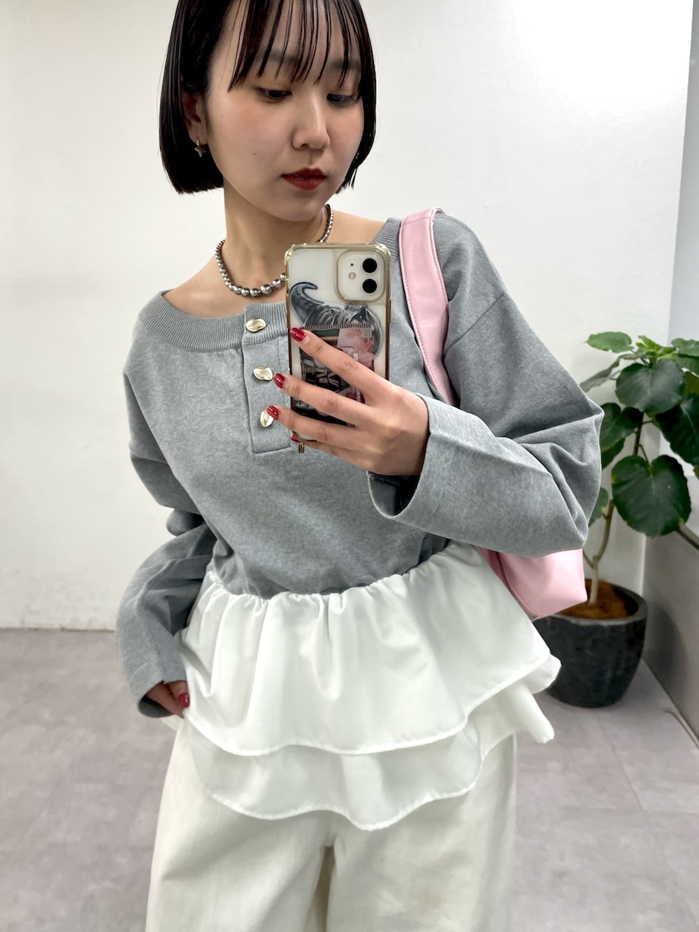 グレー系のニット/セーター、ホワイト系のデニムパンツを着用したレディースの冬コーディネートの2枚目の写真