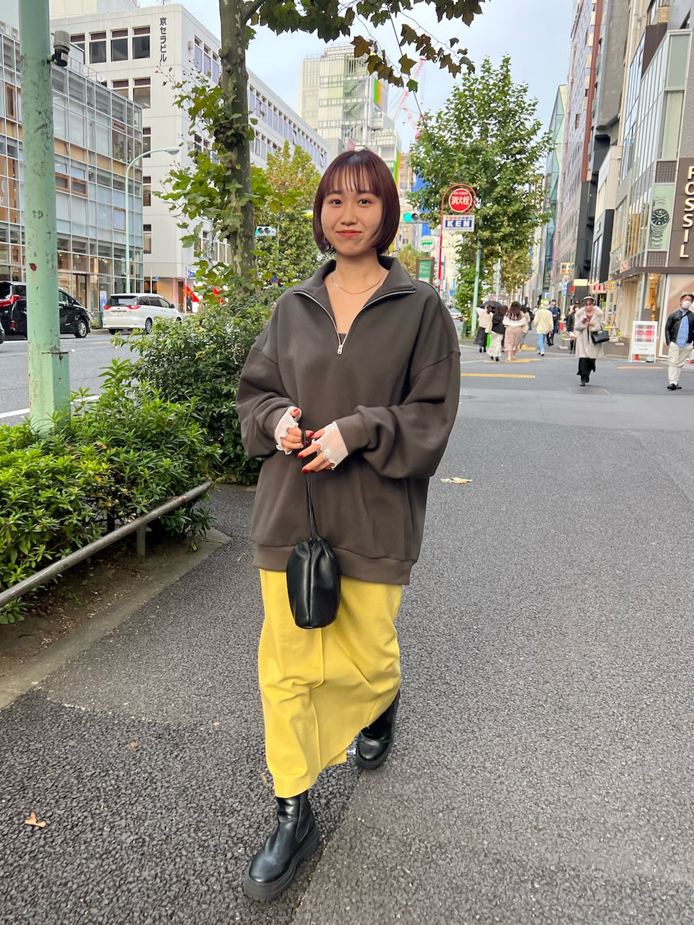 グレー系のスウェット、グリーン系のスカート、ブラック系のブーツを着用したレディースの秋コーディネートの2枚目の写真