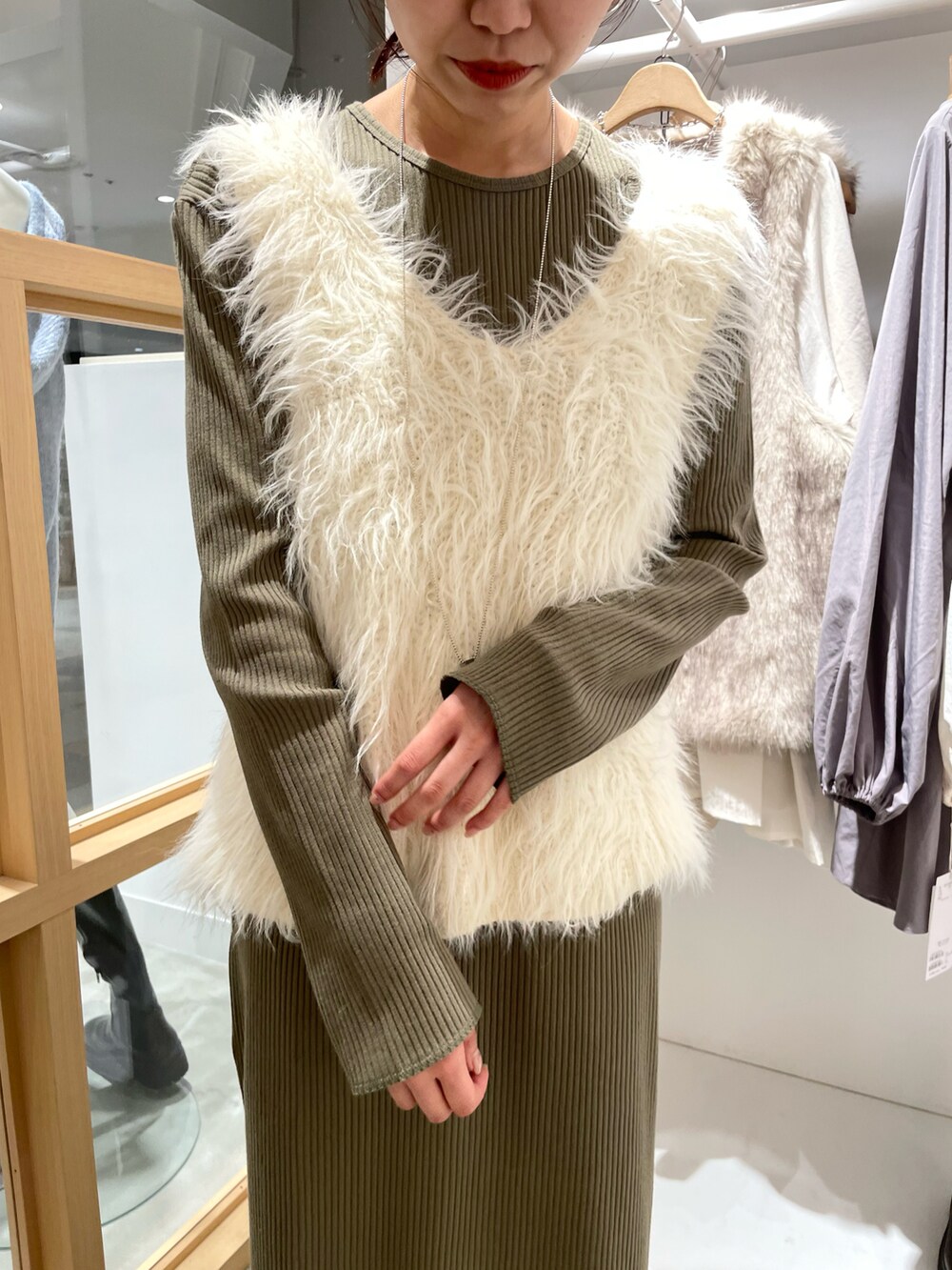 グリーン系のワンピース、ホワイト系のベストを着用したレディースの秋コーディネートの5枚目の写真