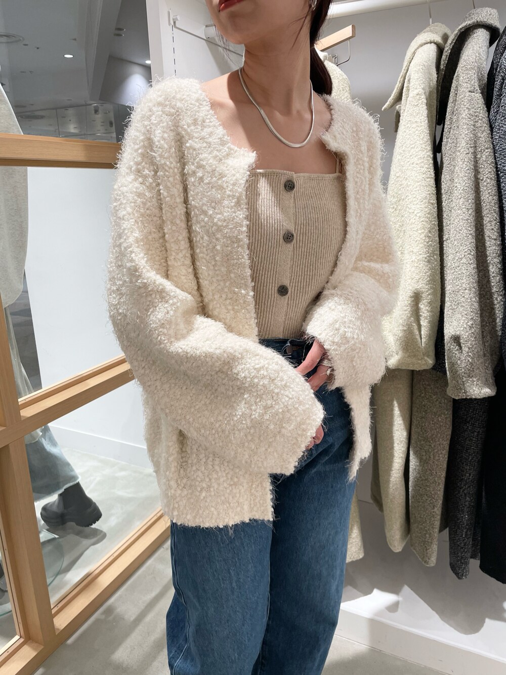 ブルー系のデニムパンツ、ホワイト系のカーディガン/ボレロを着用したレディースの秋コーディネートの4枚目の写真