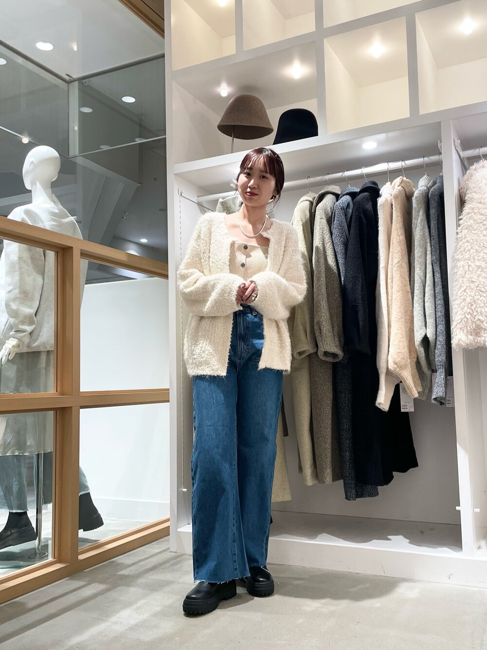 ブルー系のデニムパンツ、ホワイト系のカーディガン/ボレロを着用したレディースの秋コーディネートの2枚目の写真