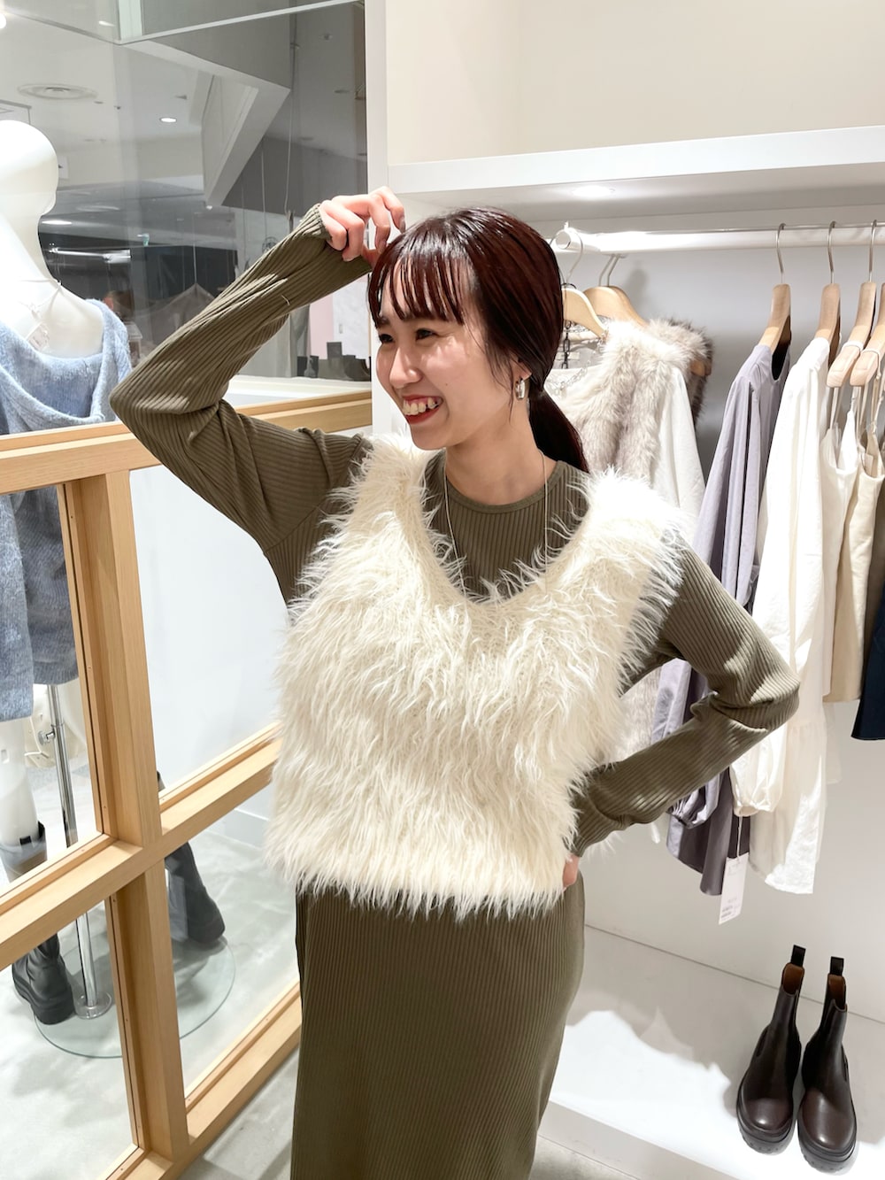 グリーン系のワンピース、ホワイト系のベストを着用したレディースの秋コーディネートの3枚目の写真