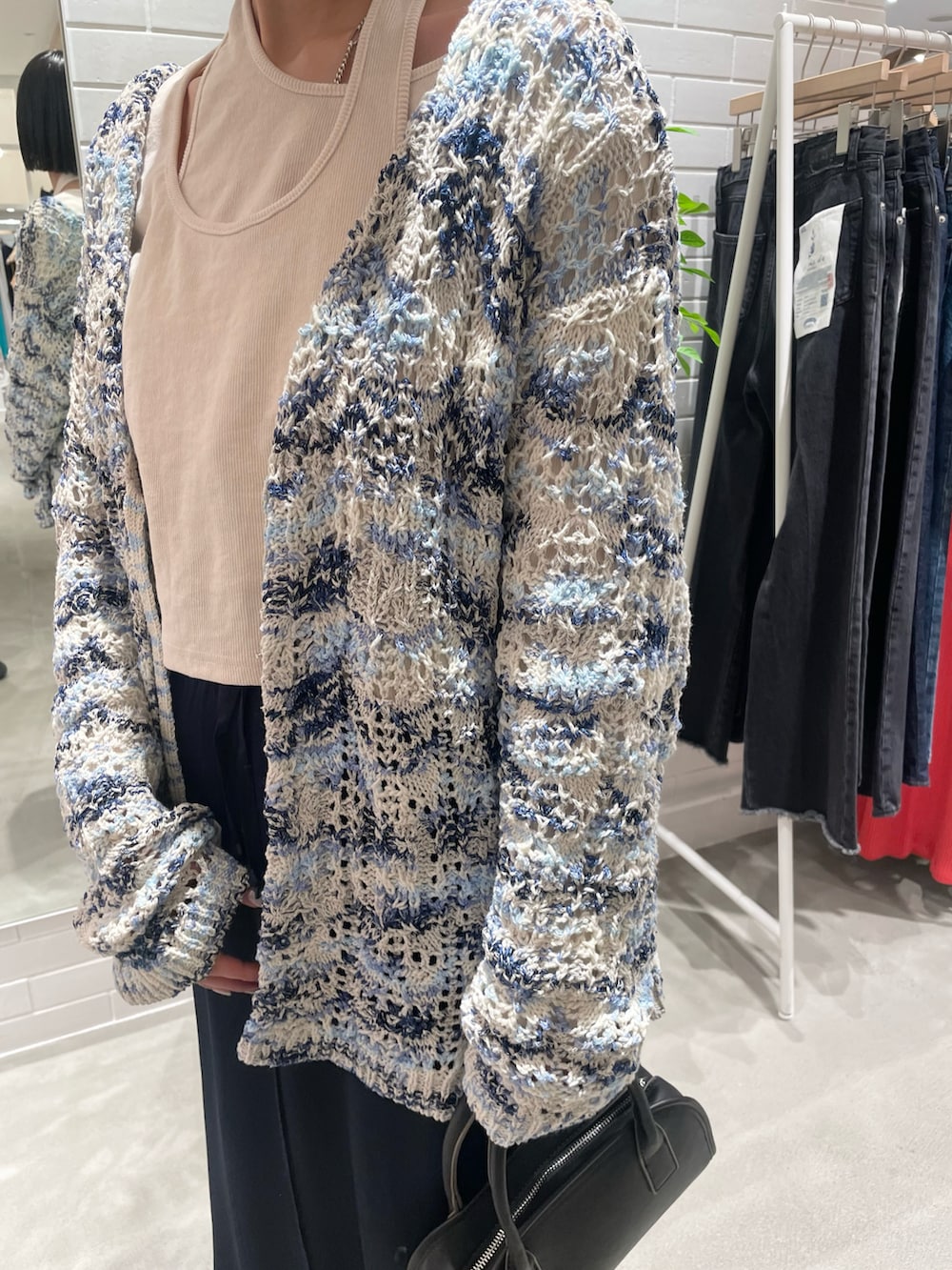 ホワイト系のTシャツ/カットソー、ブルー系のニット/セーター、ブルー系のスカートを着用したレディースの冬コーディネートの4枚目の写真