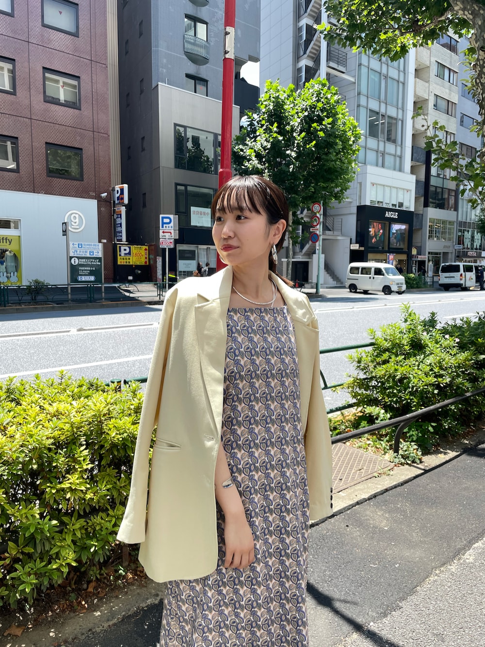 ホワイト系のテーラードジャケット、ベージュ系のワンピースを着用したレディースの夏コーディネートの2枚目の写真