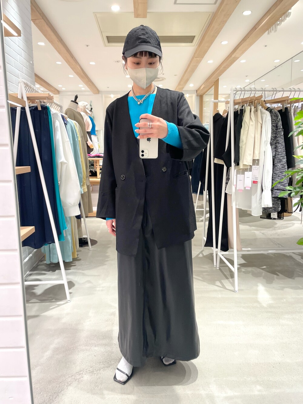 ブラック系のノーカラージャケット、ブラック系のワンピース、シルバー系のサンダルを着用したレディースの冬コーディネートの2枚目の写真