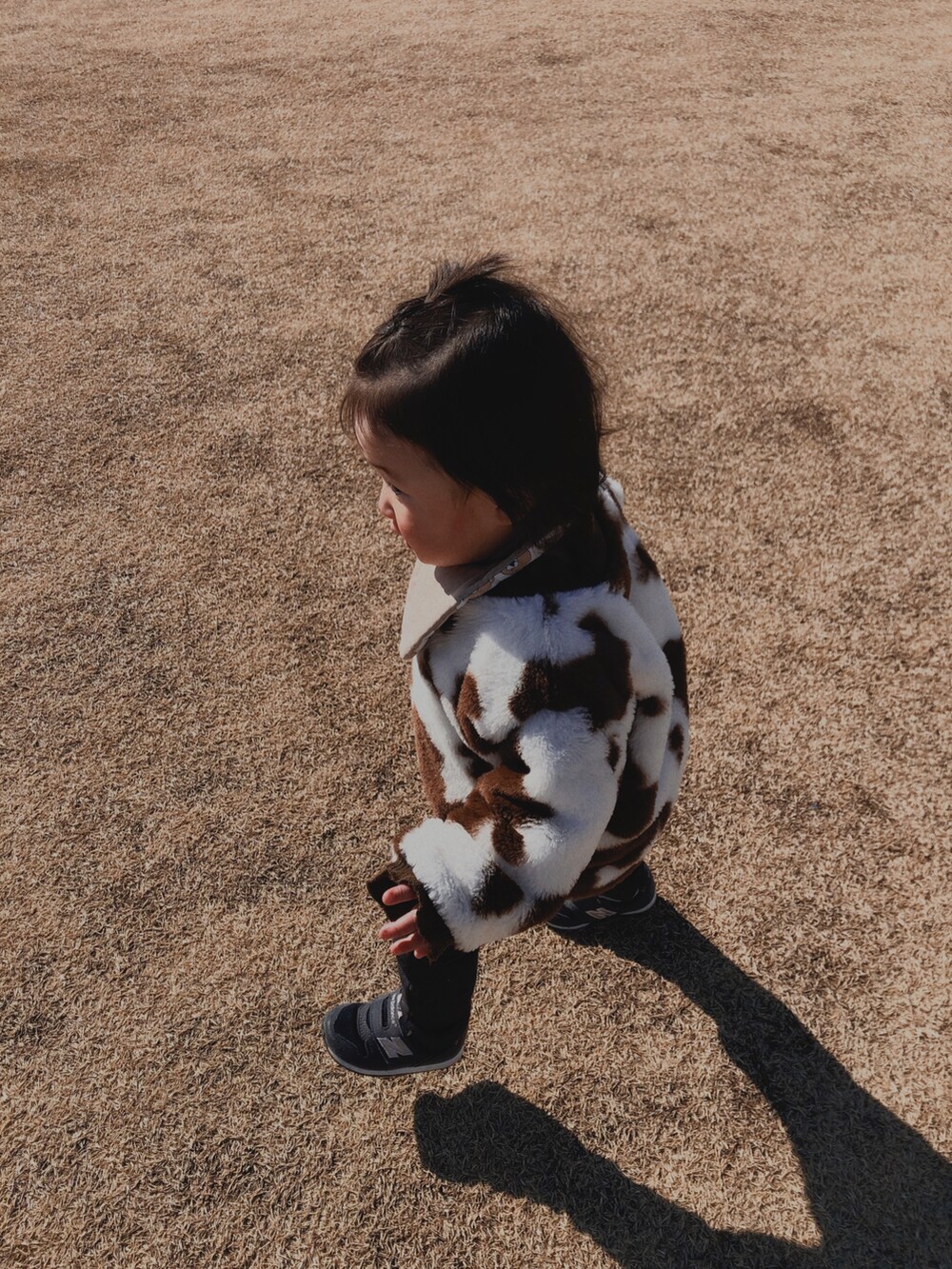 ホワイト系のトップス、ブルー系のデニムパンツ、ブルー系のスニーカーを着用したキッズの冬コーディネートの2枚目の写真