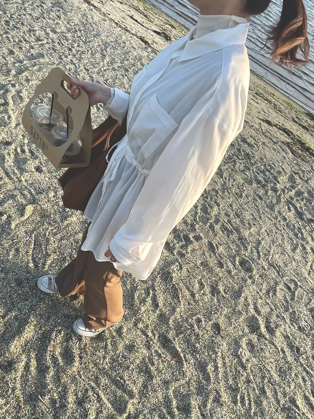 ホワイト系のシャツ/ブラウス、ブラウン系のトートバッグ、ベージュ系のスニーカーを着用したレディースの冬コーディネートの2枚目の写真