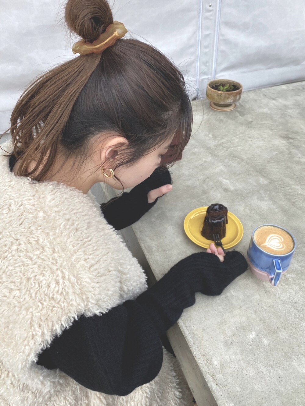 ホワイト系のブルゾン、ブラック系のワンピース、ブラウン系のパンプスを着用したレディースの秋コーディネートの2枚目の写真