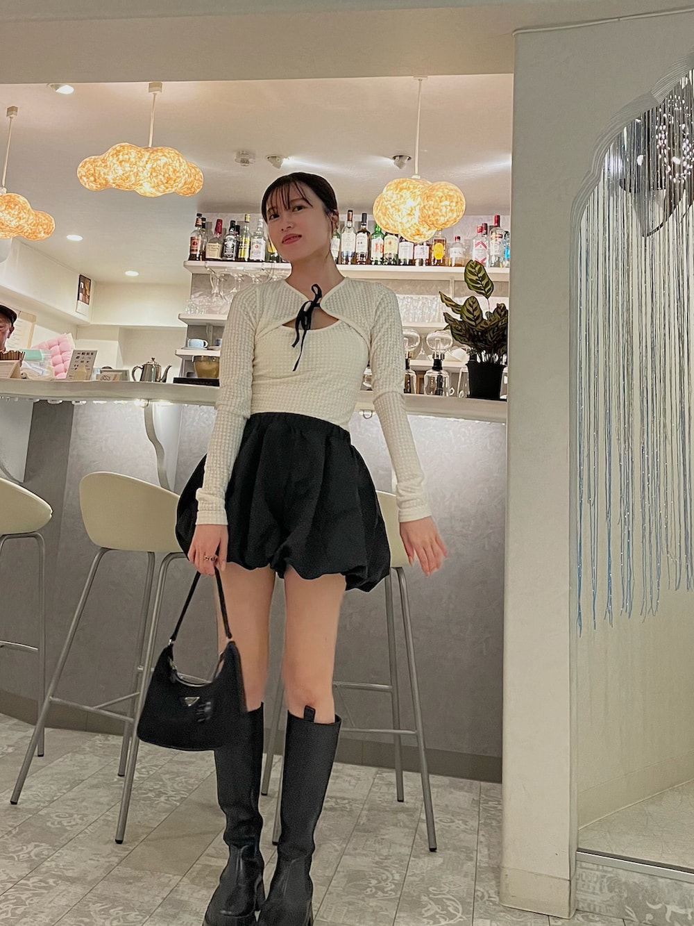 ブラック系のパンツ、ブラック系のハンドバッグ、ブラック系のブーツを着用したレディースの秋コーディネートの3枚目の写真