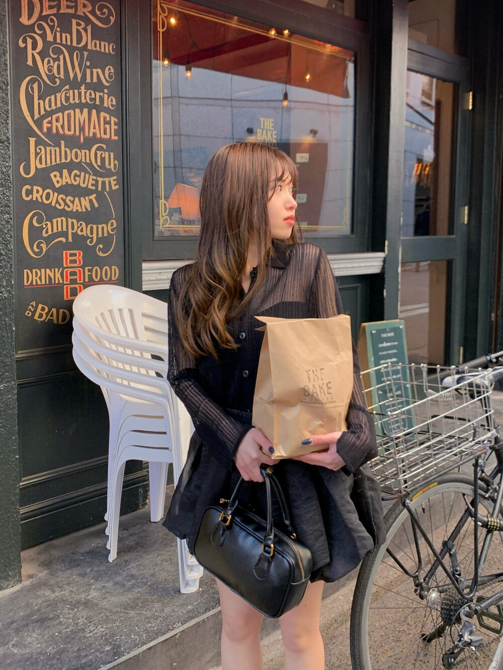 ブラック系のニット/セーター、ブラック系のハンドバッグを着用したレディースの春コーディネートの3枚目の写真