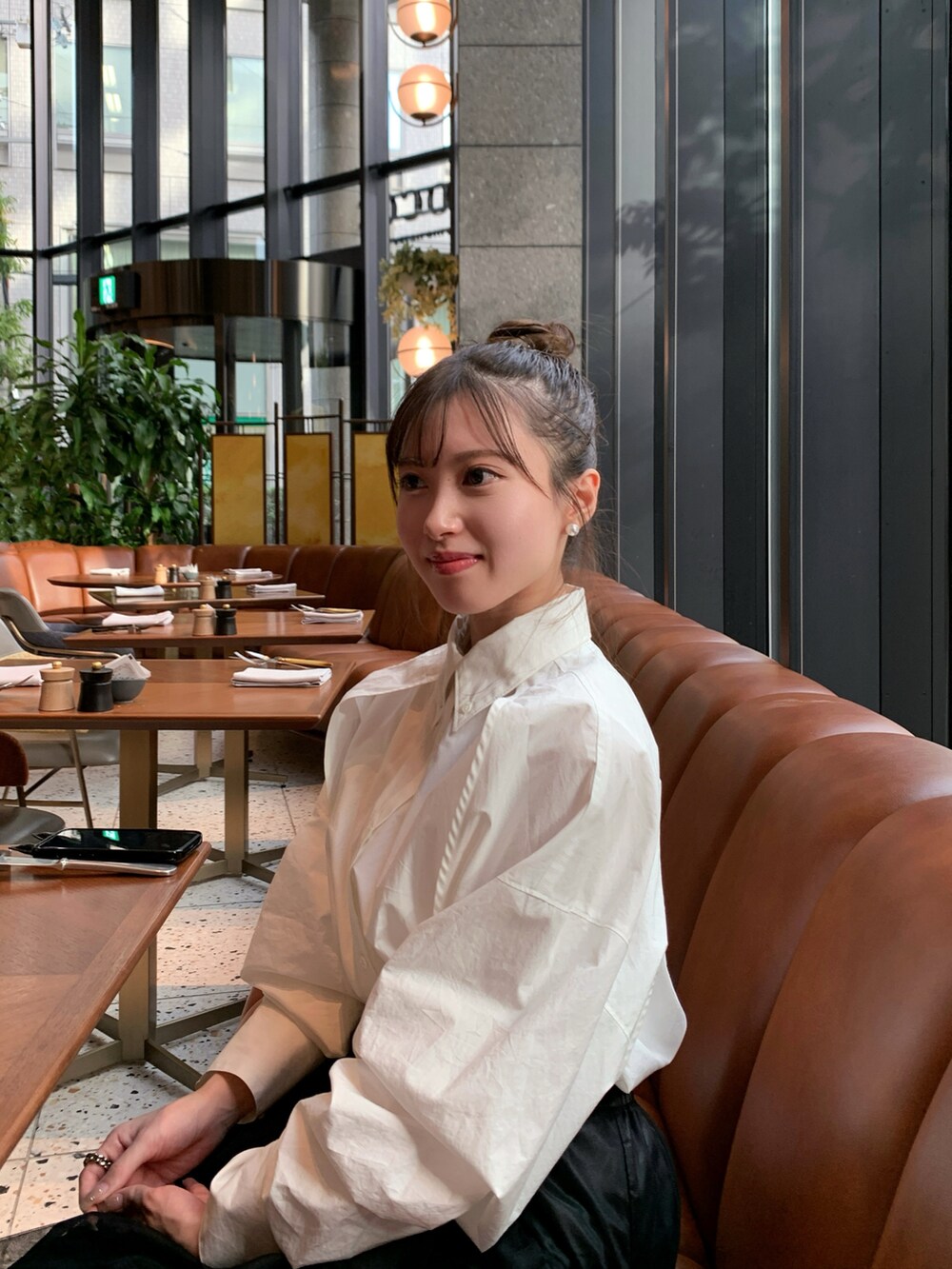 ブラック系のハンドバッグ、ブラック系のスカート、ホワイト系のスニーカーを着用したレディースの冬コーディネートの2枚目の写真