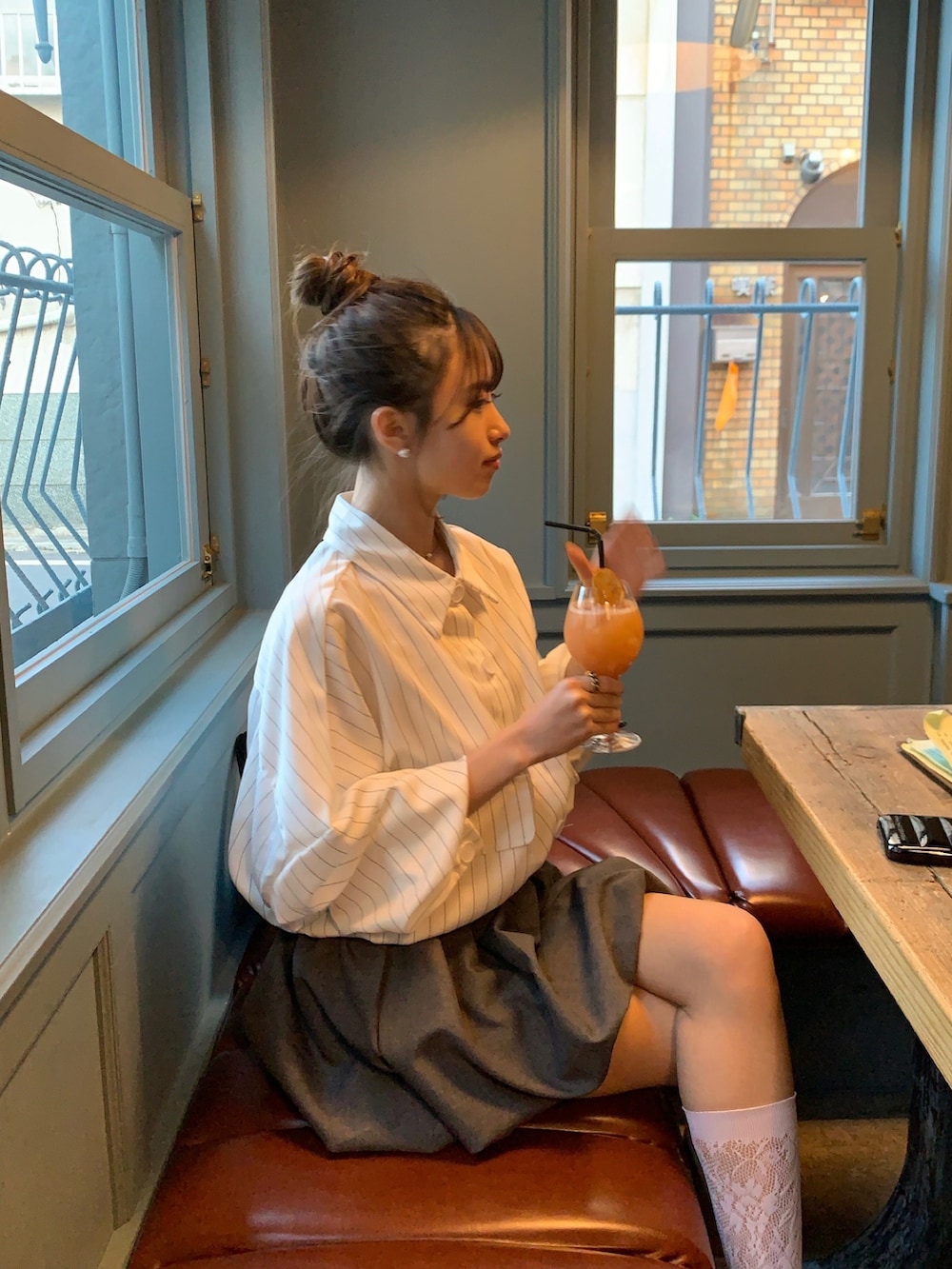 グレー系のスニーカー、ブラック系のハンドバッグ、グレー系のスカートを着用したレディースの春コーディネートの3枚目の写真