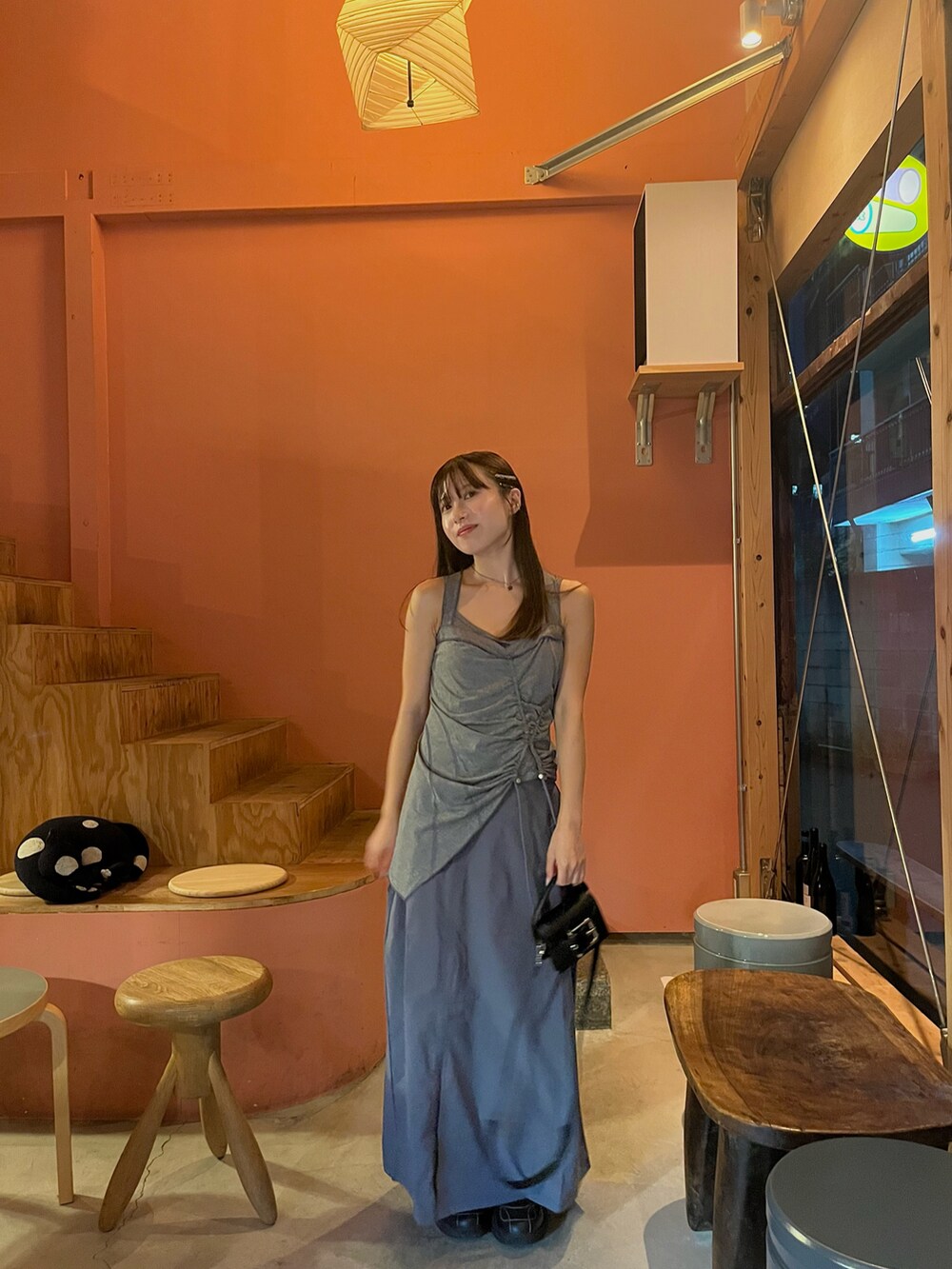 グレー系のワンピース、ブラック系のスニーカー、ブラック系のショルダーバッグを着用したレディースの秋コーディネートの2枚目の写真