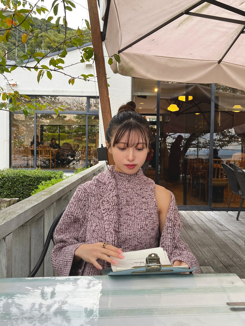 ピンク系のその他アウター、ピンク系のワンピース、ブラック系のハンドバッグを着用したレディースの秋コーディネートの3枚目の写真