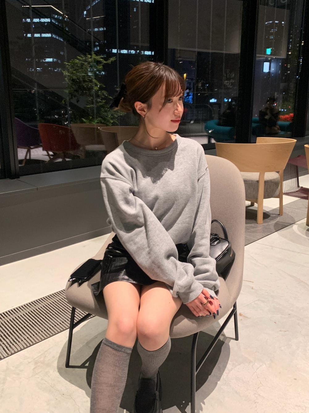 グレー系のスウェット、ブラック系のスカート、ホワイト系のローファーを着用したレディースの春コーディネートの3枚目の写真