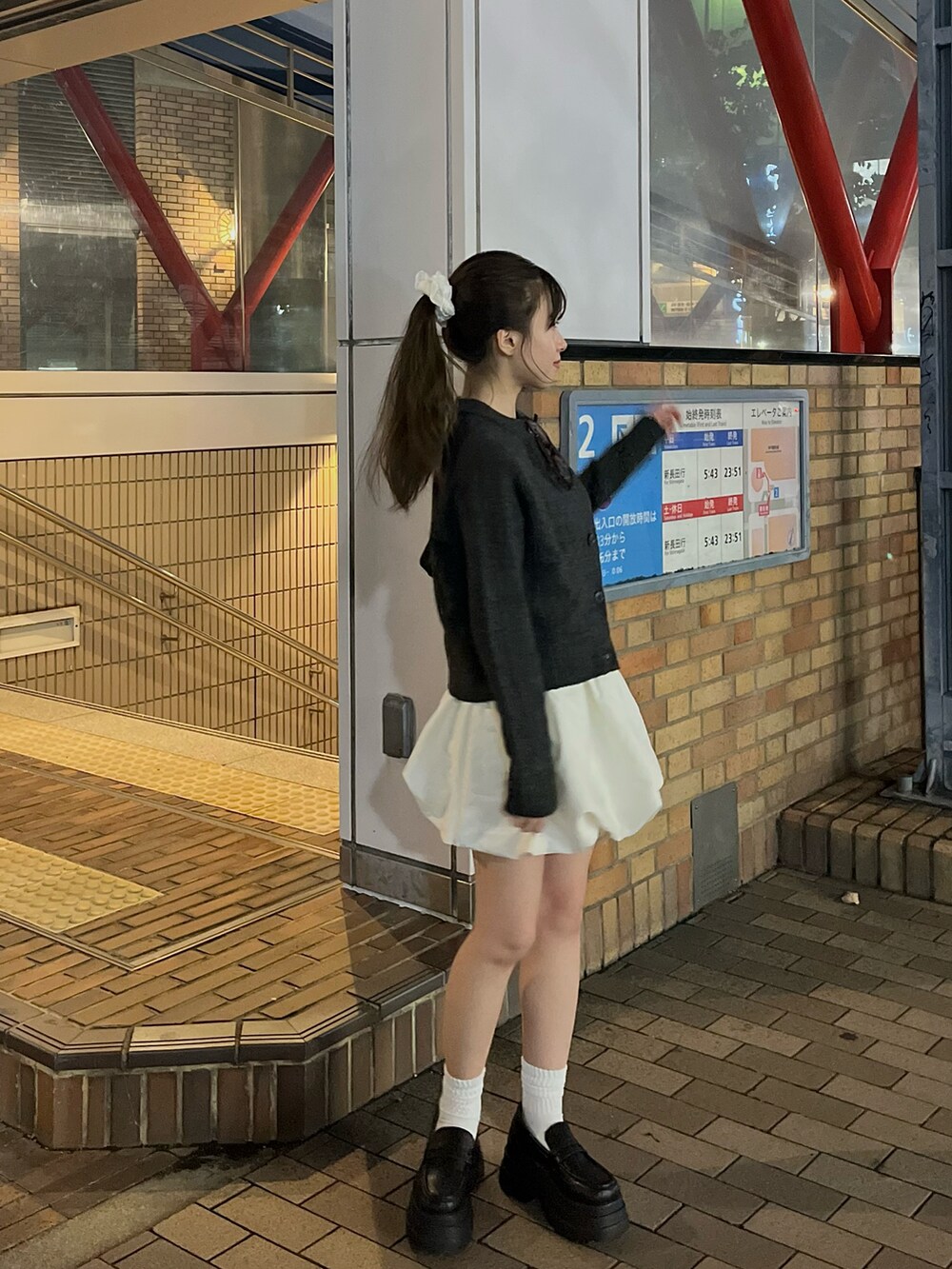 グレー系のニット/セーター、ホワイト系のパンツ、ブラック系のローファーを着用したレディースの秋コーディネートの2枚目の写真