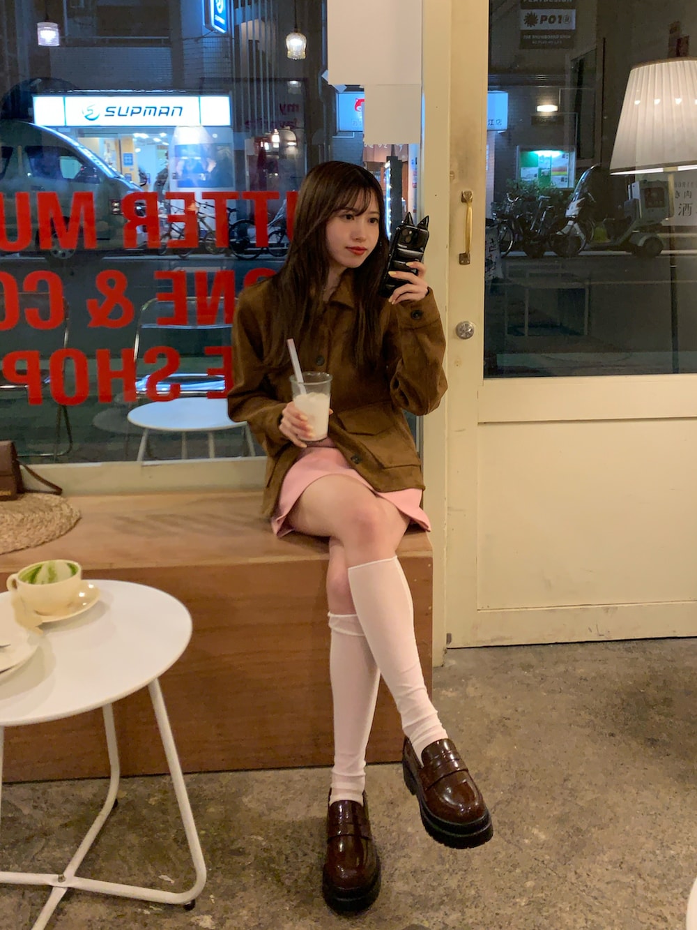 ブラウン系のローファー、ピンク系のスカート、ブラウン系のその他アウターを着用したレディースの春コーディネートの2枚目の写真