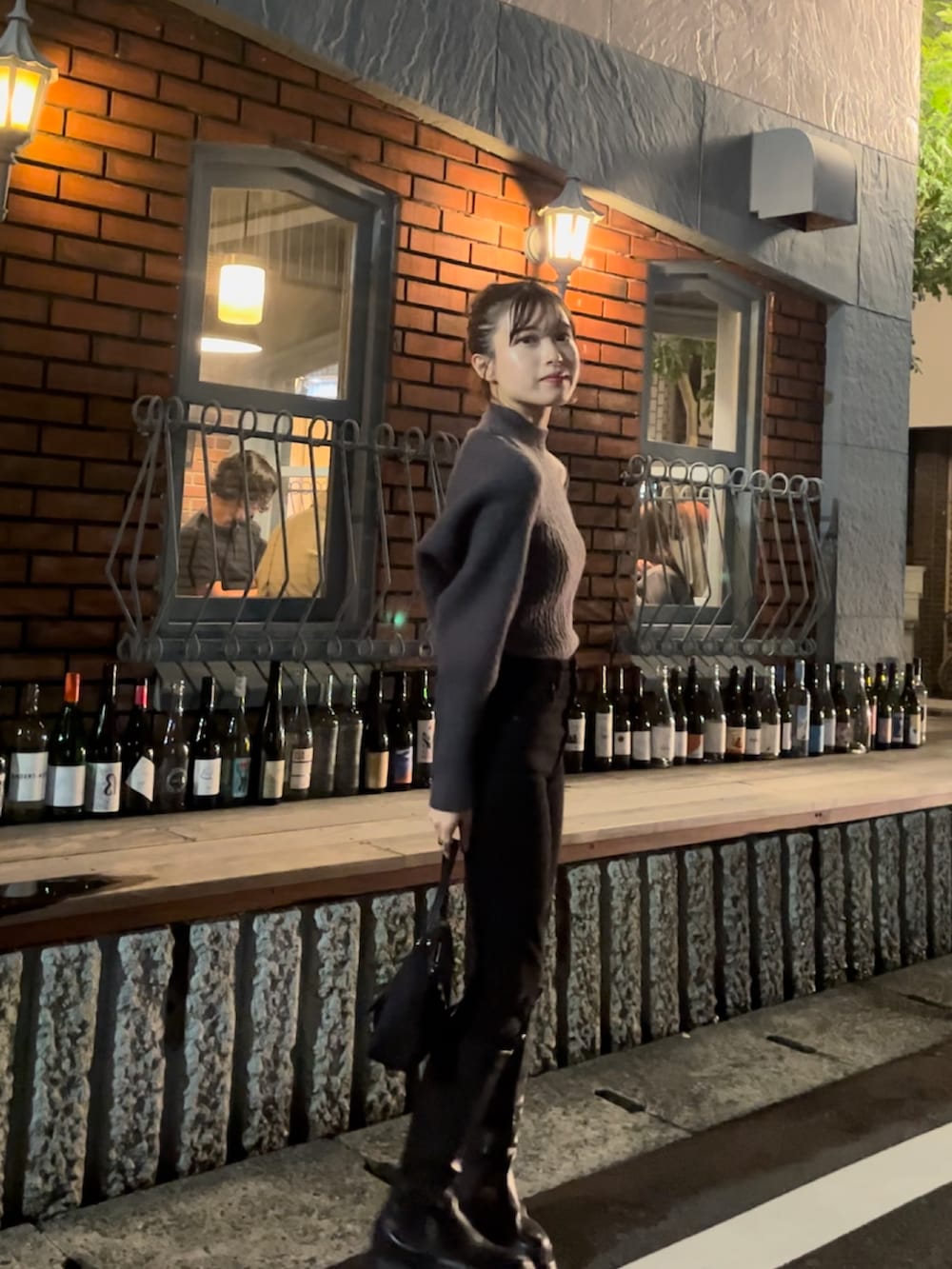 グレー系のニット/セーター、ブラック系のデニムパンツ、ブラック系のブーツを着用したレディースの秋コーディネートの4枚目の写真