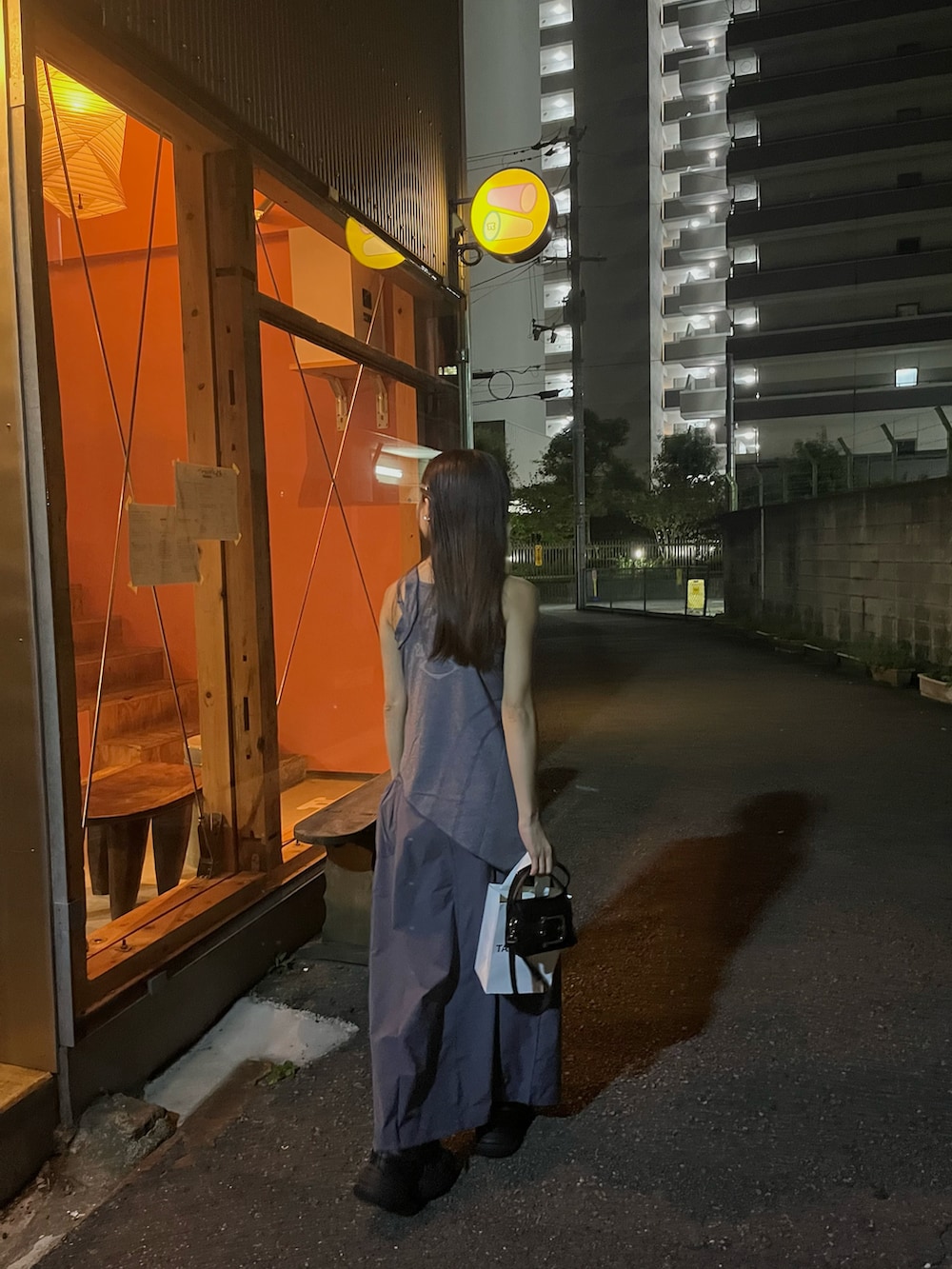 グレー系のワンピース、ブラック系のスニーカー、ブラック系のショルダーバッグを着用したレディースの秋コーディネートの3枚目の写真