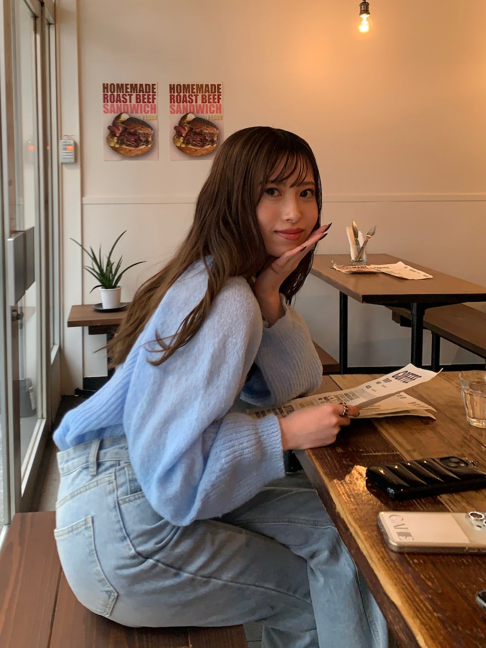 ブルー系のニット/セーター、ブラック系のローファー、ブラウン系のハンドバッグを着用したレディースの春コーディネートの2枚目の写真