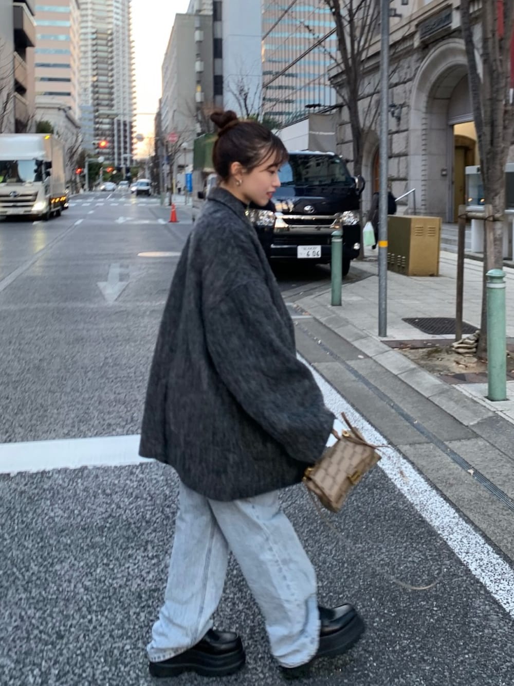 ブルー系のデニムパンツ、ブラック系のローファー、ブラック系のチェスターコートを着用したレディースの冬コーディネートの3枚目の写真