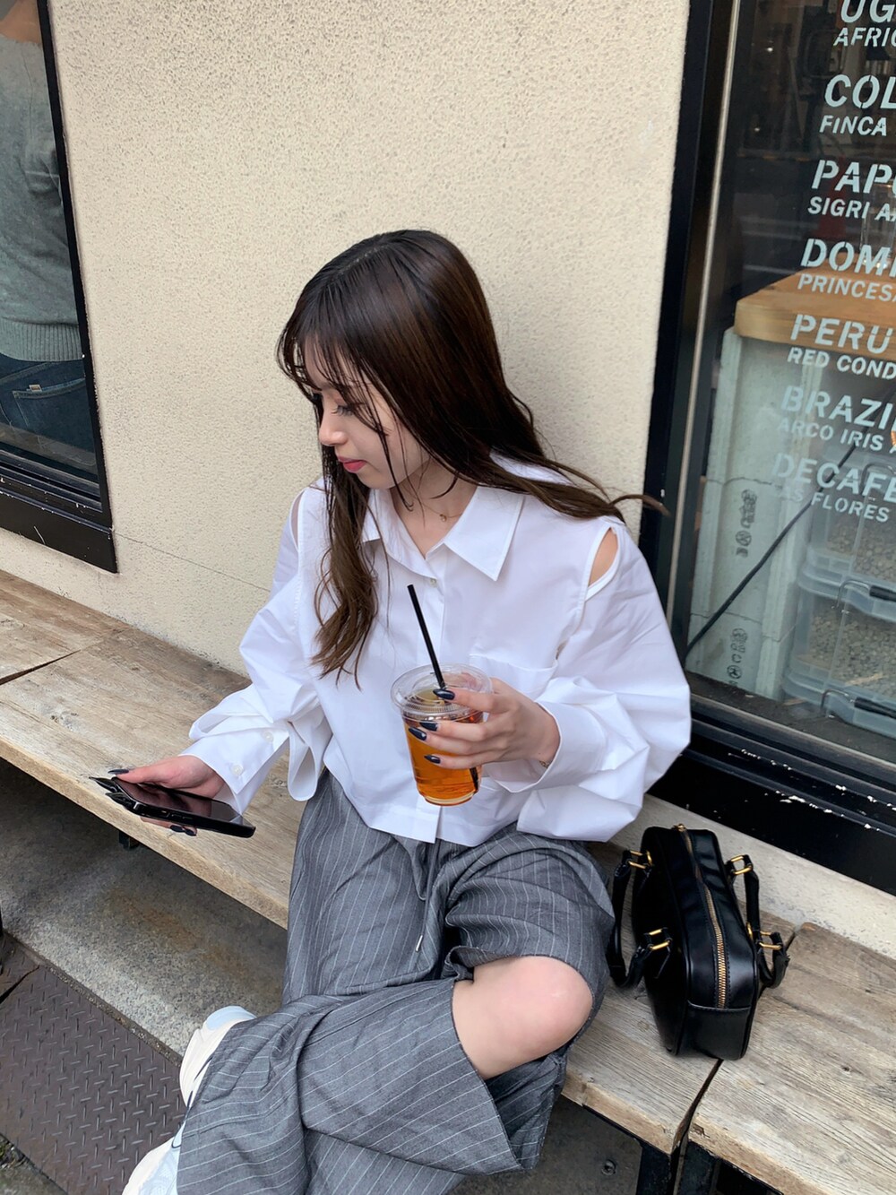 グレー系のスラックス、グレー系のスニーカー、ブラック系のハンドバッグを着用したレディースの春コーディネートの4枚目の写真