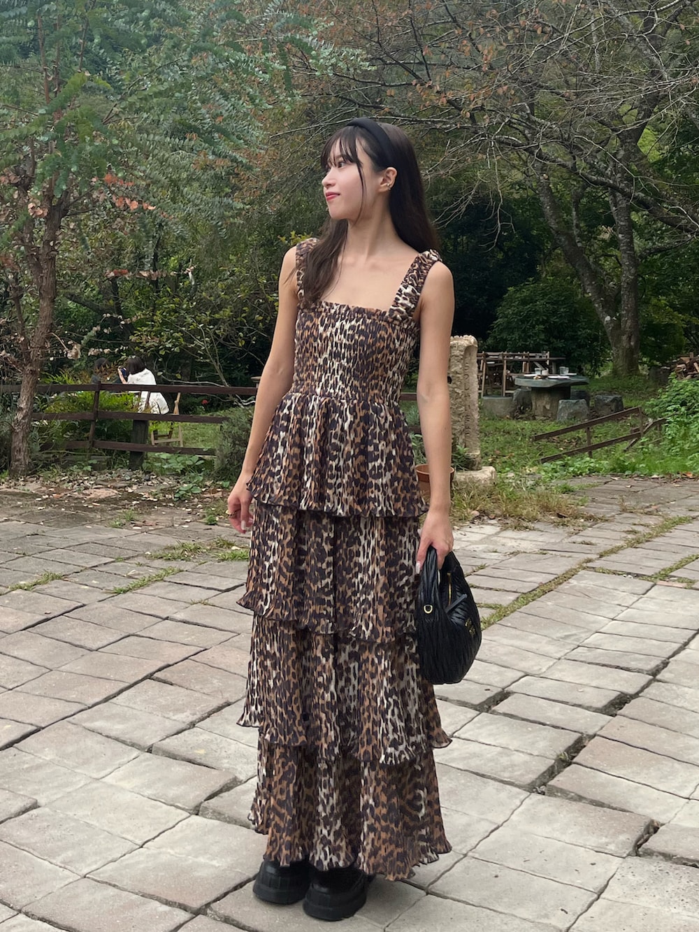 ブラウン系のワンピース/ドレス、ブラック系のハンドバッグ、ブラック系のブーツを着用したレディースの秋コーディネートの3枚目の写真