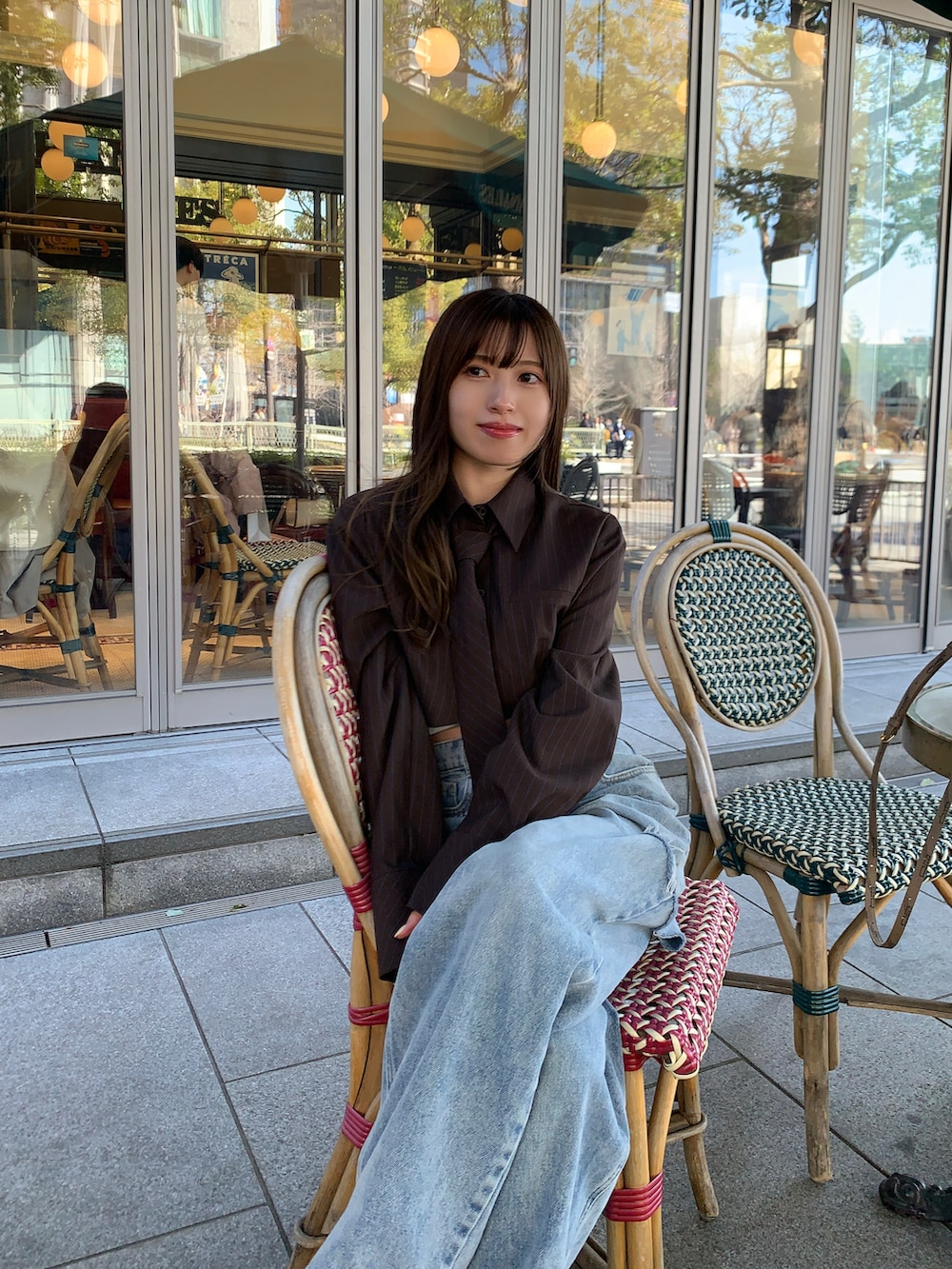 ホワイト系のスニーカー、ブルー系のデニムパンツ、ブラウン系のシャツ/ブラウスを着用したレディースの春コーディネートの2枚目の写真