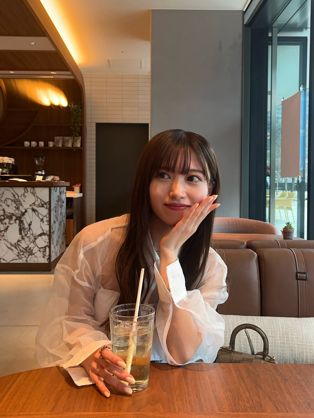 ホワイト系のシャツ/ブラウス、ブルー系のデニムパンツ、ベージュ系のショルダーバッグを着用したレディースの春コーディネートの2枚目の写真