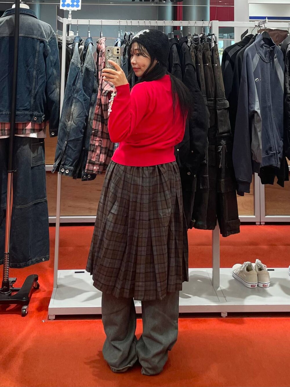 ブラック系のハンドバッグ、ブラウン系のスカート、ブルー系のデニムパンツを着用したレディースの秋コーディネートの3枚目の写真