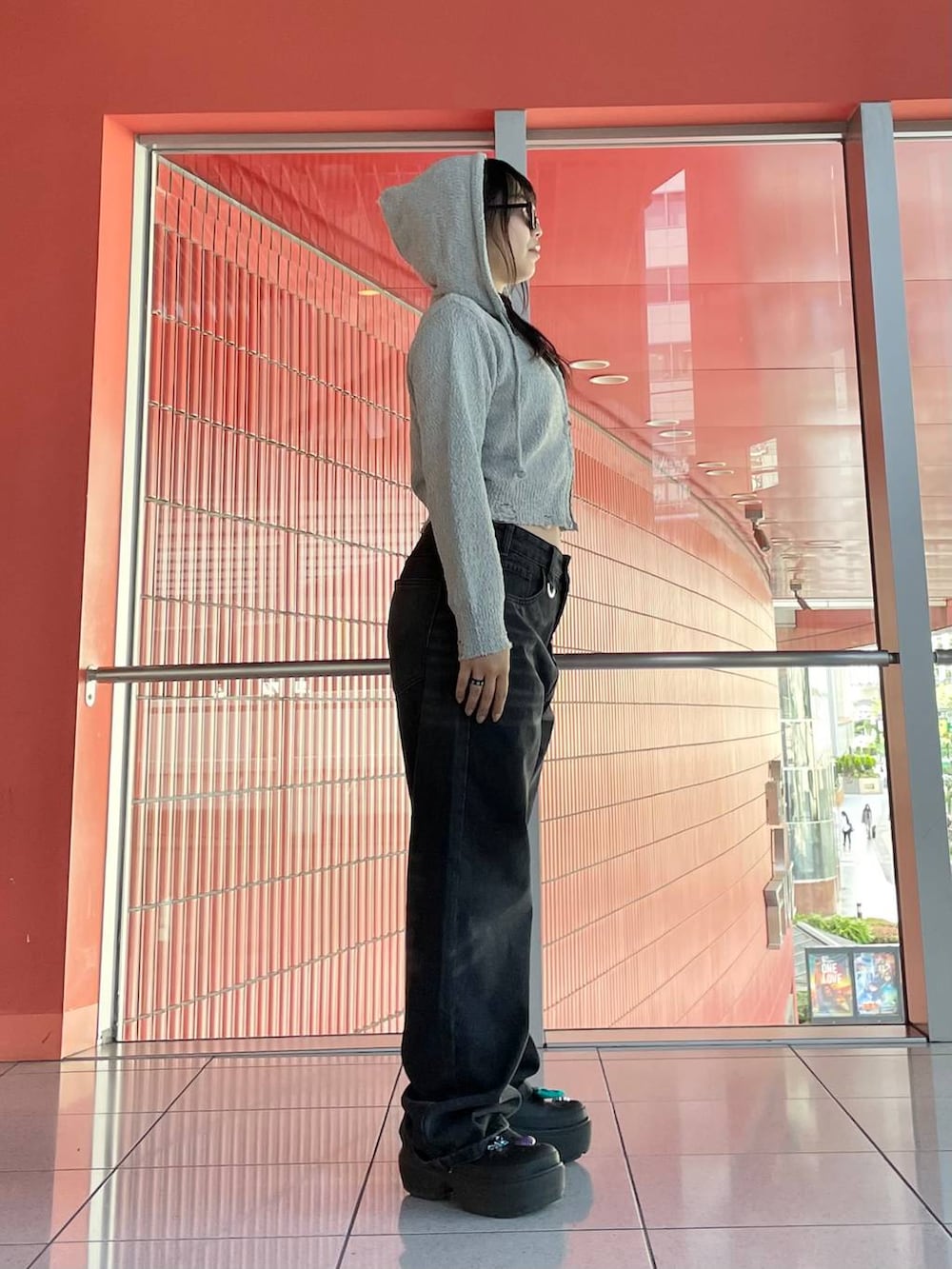 ブルー系のキャミソール、ブラック系のデニムパンツ、グレー系のパーカーを着用したレディースの春コーディネートの2枚目の写真