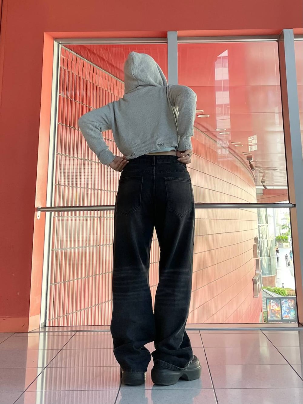 ブルー系のキャミソール、ブラック系のデニムパンツ、グレー系のパーカーを着用したレディースの春コーディネートの3枚目の写真