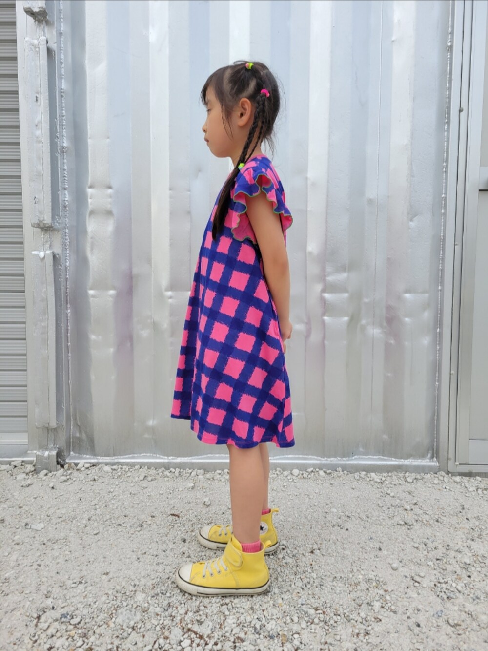 ピンク系のワンピース、イエロー系のスニーカーを着用したキッズの春コーディネートの3枚目の写真