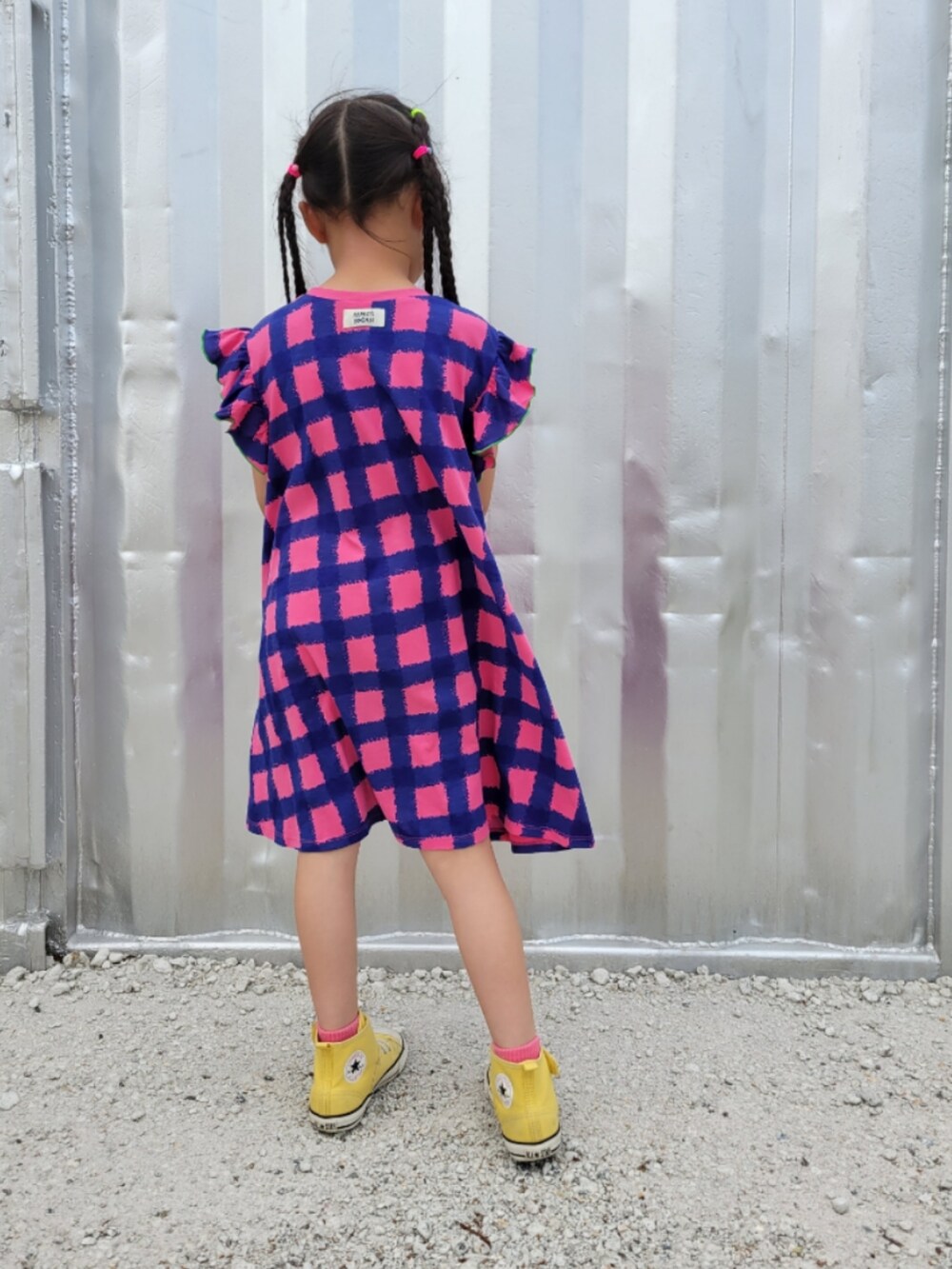 ピンク系のワンピース、イエロー系のスニーカーを着用したキッズの春コーディネートの4枚目の写真
