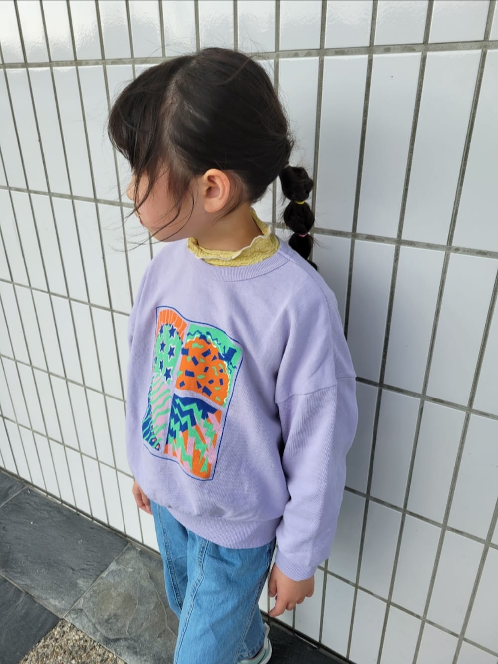 グリーン系のスニーカー、パープル系のスウェット、イエロー系のTシャツ/カットソーを着用したキッズの春コーディネートの3枚目の写真