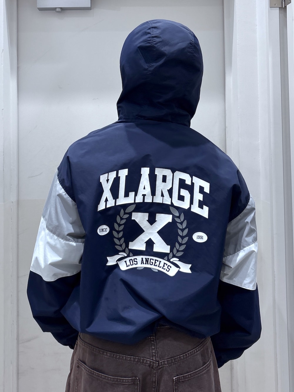 ブラウン系のデニムパンツ、ブルー系のブルゾン、ブラック系のバックパック/リュックを着用したメンズの秋コーディネートの5枚目の写真