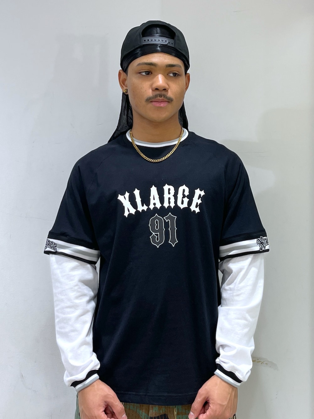 「カーゴパンツ、Tシャツ、キャップ、ドゥーラグ、メイサイ柄、XLARGE」｜「XLARGEのXLARGE 91 LAYERD L/S TEE（Tシャツ/カットソー、ブラック系）」を使った、CHRISさん（骨格ウェーブ・メンズ・172cm）の春コーディネートの2枚目の写真