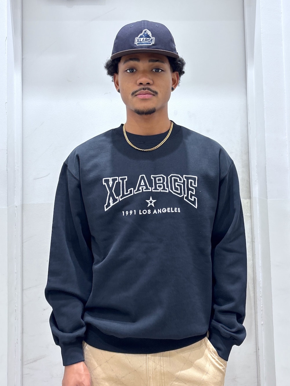 ブラック系のスウェット、ベージュ系のカーゴパンツ、ブルー系のキャップを着用したメンズの秋コーディネートの3枚目の写真