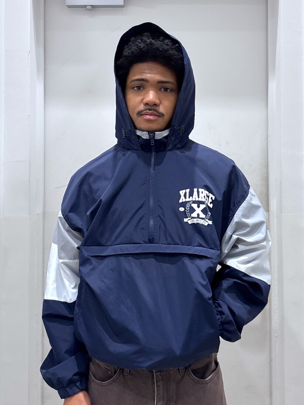 ブラウン系のデニムパンツ、ブルー系のブルゾン、ブラック系のバックパック/リュックを着用したメンズの秋コーディネートの4枚目の写真