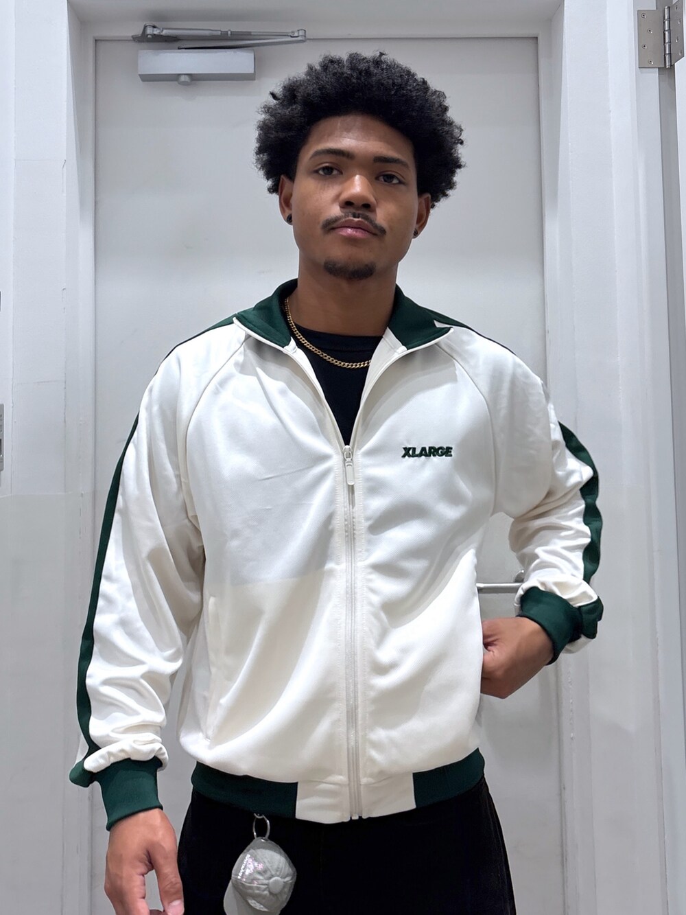 ホワイト系のブルゾン、ブラック系のその他パンツ、グレー系のキーホルダーを着用したメンズの秋コーディネートの3枚目の写真