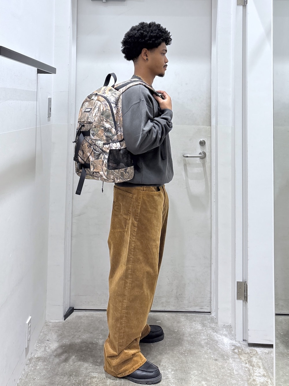 ベージュ系のバックパック/リュック、ブラック系のスウェット、ブラウン系のその他パンツを着用したメンズの秋コーディネートの2枚目の写真