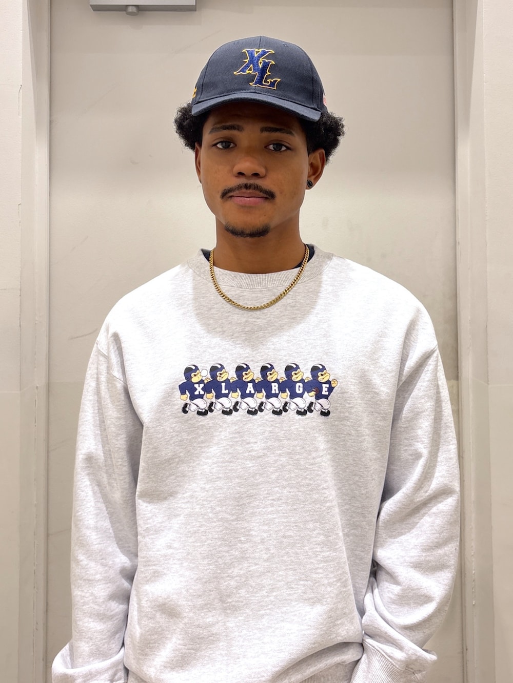 グレー系のスウェット、ホワイト系のその他パンツ、ブルー系のキャップを着用したメンズの秋コーディネートの3枚目の写真