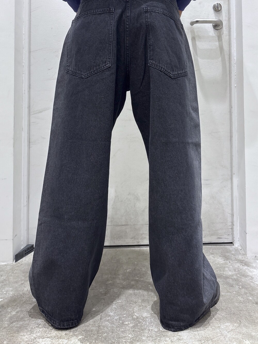 ブラック系のパーカー、パープル系のTシャツ/カットソー、ブラック系のデニムパンツを着用したメンズの秋コーディネートの6枚目の写真