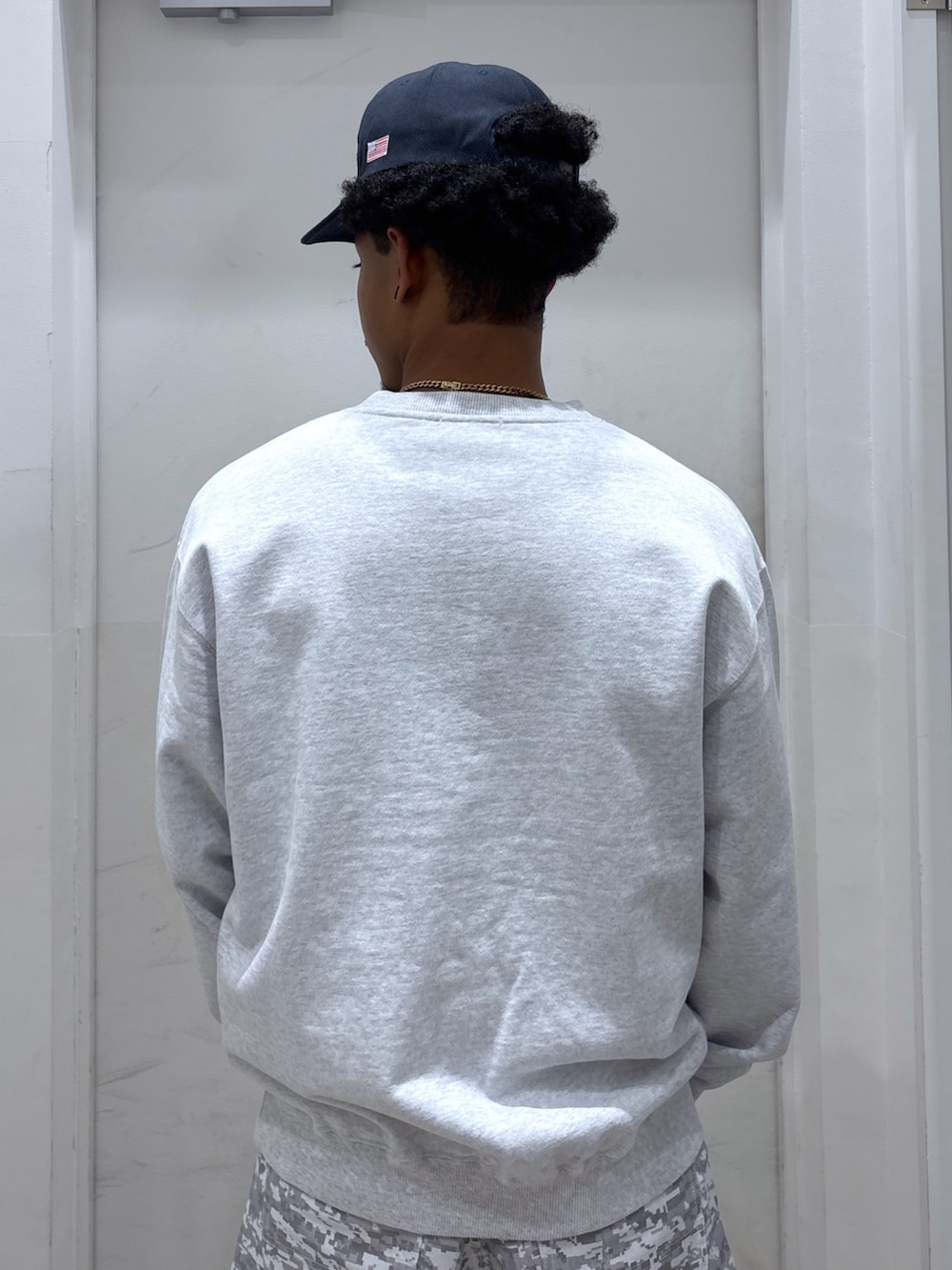 グレー系のスウェット、ホワイト系のその他パンツ、ブルー系のキャップを着用したメンズの秋コーディネートの4枚目の写真