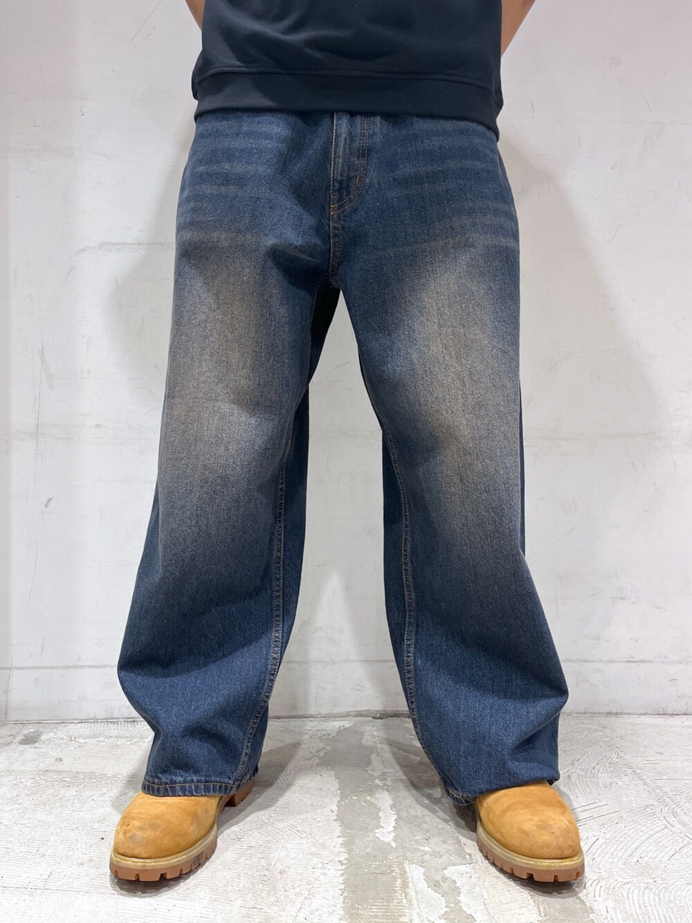 ブラック系のベスト、ブルー系のデニムパンツを着用したメンズの春コーディネートの3枚目の写真